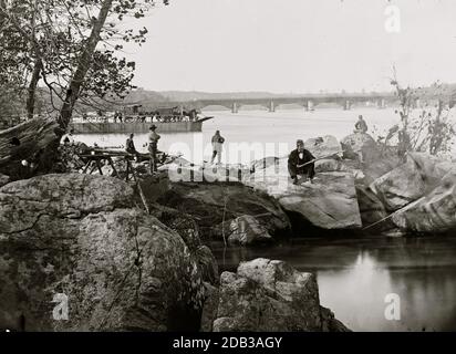 Washington, D.C. Georgetown Fähre-Boot mit Waggons, und Aqueduct Bridge darüber hinaus, von Felsen auf Mason's Island. Stockfoto