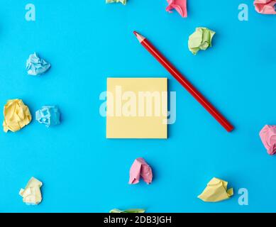 Bunte leere Papieraufkleber in verschiedenen Farben und Holzbleistift auf blauem Hintergrund, Kopierraum Stockfoto