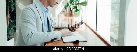 Online-Training ein Student schreibt den Text einer Vorlesung Von ihrem Telefon zu einem Notepad Stockfoto