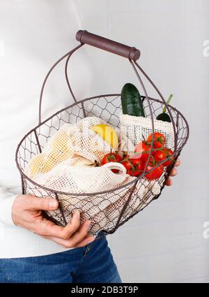 Frau hält sich mit frischem Gemüse und Fuit in Textilbeuteln zurück Stockfoto
