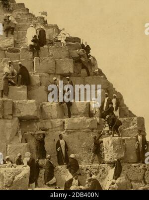 Mehrere Leute versammelten sich am Fuß der Großen Pyramide, andere kletterten. Stockfoto