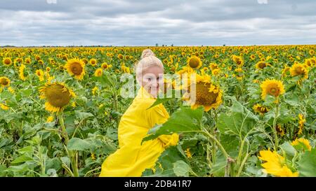 Glückliche Frau in gelbem Kleid mit einem freundlichen Blick in Heißes, sonniges Wetter Stockfoto