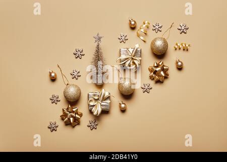 Goldene weihnachtsdekoration und Kugel auf beigefarbenem Hintergrund. Kreatives Layout in neutralen Schwarzweiß-Farben Stockfoto