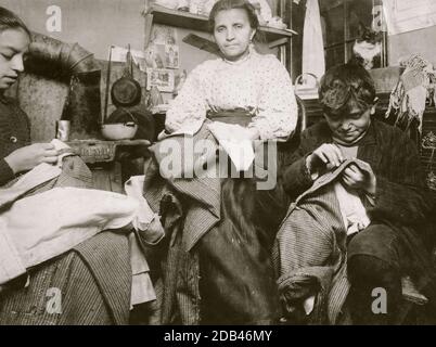 Hoch oben im obersten Stockwerk eines zackigen Mietskaserne, Immigranten 214 Elizabeth St., N.Y., diese Mutter und ihre zwei Kinder, Junge 10 Jahre alt und das Mädchen 12, lebten in einem winzigen Raum, und waren fertig Kleidungsstücke. Die Kleidungsstücke wurden unter dem Bett und darüber und im Zimmer gepackt. Sagte, die Marke von 1 bis 2 Dollar pro Woche, und die Jungs [sic] verdient einige verkaufen Zeitungen. . Stockfoto