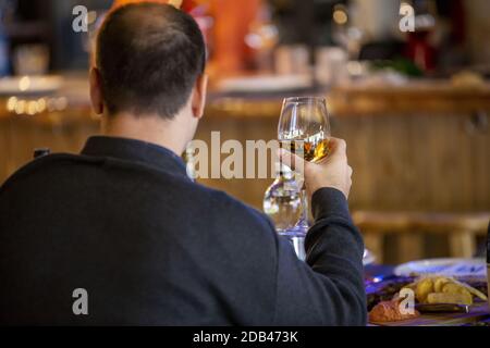 Eine selektive Fokusaufnahme eines Mannes, der Champagner trinkt Stockfoto