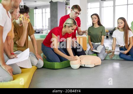 Junge Frau Frage stellen, wie man das Leben von Lehrer zu retten, Praxis auf Dummy Stockfoto