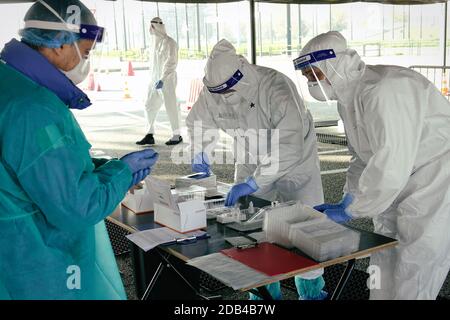 Medizinisches Personal in PSA, das Nasen- und Rachenabstrich an Person im Fahrzeug durch Autofenster durchführt, mobiles Testzentrum COVID-19. Turin, Italien - 2. November Stockfoto