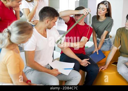 Im ersten-Hilfe-Unterricht lernen die Schüler, die Hand des verletzten Patienten mit einer Bandage zu schnappen Stockfoto