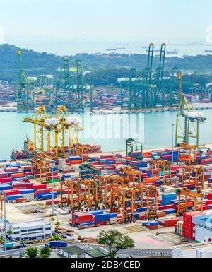Luftbild des Handelshafens in Singapur, schwere Ausrüstung, Frachtcontainer, Frachtkräne, Docks und Lagerplätze, Hafen mit Schiffen und Tankern Stockfoto