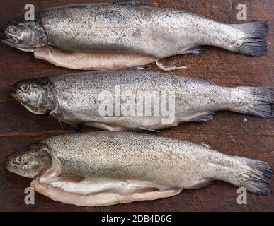 Frischer geschälter Forellenfisch auf einem braunen Schneidebrett, Draufsicht Stockfoto