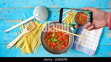 Shooting mit Smartphone die Vorbereitung von oganic italienische Spaghetti-Gericht, Spaghetti, Küchenutensilien, gesundes Essen, Kochen, Restaurant, Konzept Stockfoto