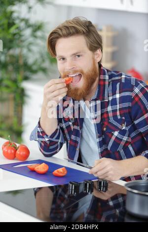Mann mit einer Tomate in der Hand schaut nach oben Stockfoto