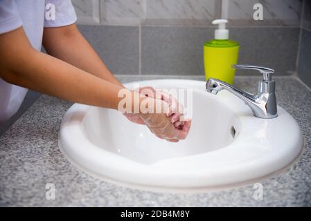 Frau waschen Sie die Handreinigung mit Seife im Waschbecken, desinfizieren Sie das Coronavirus, oder verhindern Sie die Ausbreitung des Covid 19-Ausbruchs, gutes Hygieneprogramm Stockfoto