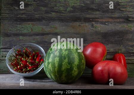 Stillleben Makro Foto von Paprika und Wassermelone mit Tomaten Auf verwittertem Holzhintergrund Stockfoto