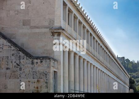 Athen Griechenland. Attalus stoa Fassadensäulen, Akropolis Felsenhintergrund, blauer Himmel, sonniger Tag. Stockfoto