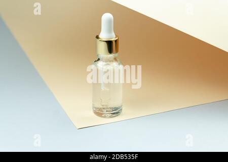 Kosmetische Ölflasche mit Pipette Tropf auf tan Hintergrund. Hautpflege-Konzept. Naturkosmetik. Moderner Beauty-Trend Stockfoto