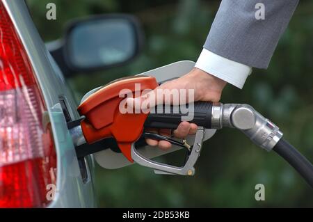 Mann pumpt Benzin mit Kraftstoffpumpe. Tankstelle für Fahrzeuge an der Tankstelle. Der Benzinpreis sinkt nach der Pandemie Coronavirus, niedriger Kraftstoffpreis. Stockfoto