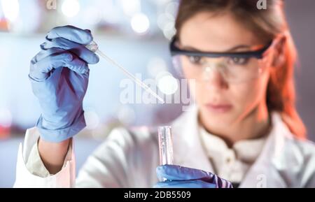 Life-Wissenschaftler forschen im Labor. Konzentrierte sich weibliche Biowissenschaften Pipettieren Profilösung in die Glas-Küvette. Objektiv-Fokussierung auf researche Stockfoto