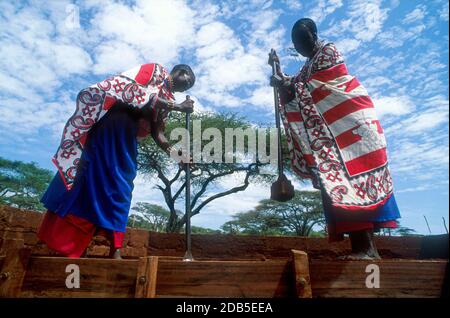 Maasai-Frauen bauen ein Haus mit gerammtem Boden, Kajiado, Kenia Stockfoto