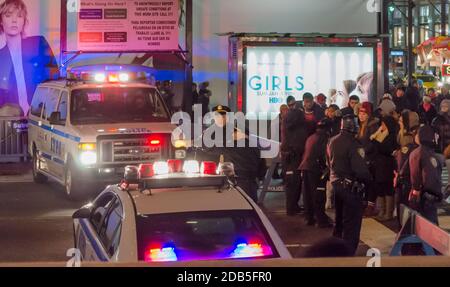 NYPD Polizeifahrzeuge und Polizisten blockierten die Straße wegen der Silvesterfeiern am Times Square in Manhattan. Die Leute warten auf den Pass. New York, USA Stockfoto
