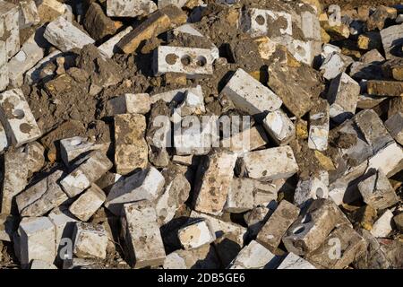 Nach der Zerstörung des alten Gebäudes stapelten sich Ziegel und andere gebrochene Baumaterialien, Nahaufnahme der Baustelle Stockfoto