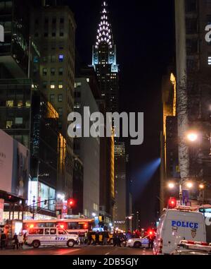NYPD Polizeifahrzeuge und Polizisten blockierten die Straße wegen der Silvesterfeiern am Times Square, New York. Die Leute warten auf den Pass. Chrysler Building Stockfoto