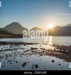 Wunderschönes Morgenlicht, das an einem ruhigen Sommermorgen durch die Berge am Wastwater im englischen Lake District scheint. Stockfoto