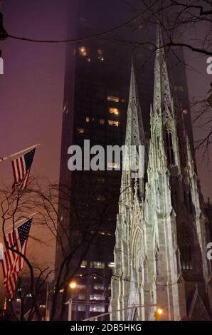 St. Patrick's Cathedral bei Nacht in Midtown Manhattan. Vereinigte Staaten von Amerika Flaggen winken stolz. New York City, USA Stockfoto