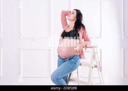 Schwangere Mädchen in Jeans und ein Hemd. Stockfoto