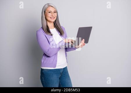 Foto-Porträt von lächelnd attraktive Senior weibliche ceo des Unternehmens Tragen Brillen arbeiten mit modernen Laptop lesen Schreiben E-Mails isoliert Ein Stockfoto