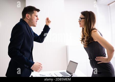 Seitenansicht Der Geschäftsleute, Die Sich Am Schreibtisch Im Büro Zerstritten Stockfoto