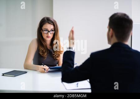 Nahaufnahme der Unternehmer Streiten für junge geschäftsfrau am Schreibtisch Stockfoto