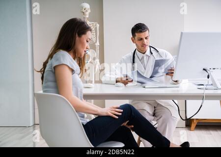 Arzt in Diskussion mit Patienten über Knie X-ray Stockfoto