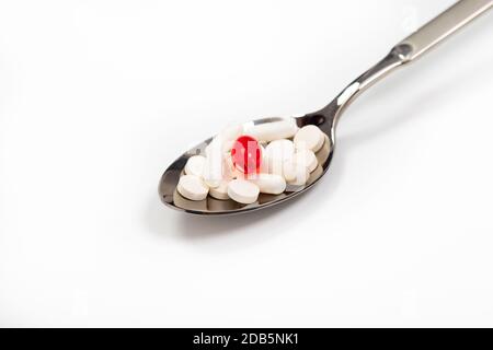 Verschiedene pharmazeutische Medikamente, Tabletten und Kapseln in einem Löffel auf weißem Hintergrund. Konzept für das Gesundheitswesen. Stockfoto