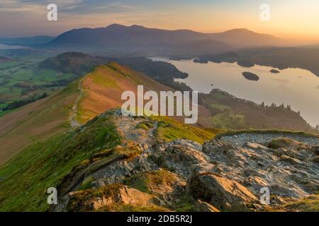 Majestätischer, pulsierender, dunstiger Sonnenaufgang an einem ruhigen Frühlingsmorgen mit Sonnenlicht, das die Landschaft des englischen Lake District erhellt. Stockfoto