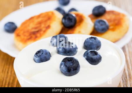 Frische leckere Heidelbeeren in weißer, dicker saurer Sahne, während der Mahlzeiten Stockfoto