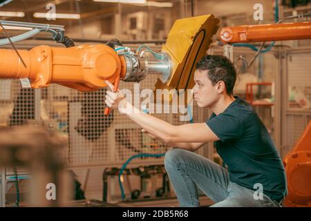 Vor dem Start des Prozesses eine Roboterlinie mit automatischen Armen einrichten. Stockfoto