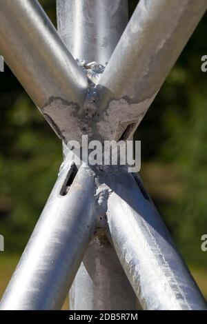 Stahlmetallstruktur aus mehreren Elementen in Form eines Rohres, das mit Hilfe eines Schweißsystems miteinander verbunden ist, Nahaufnahme Stockfoto