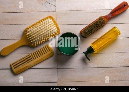 Haargel und Kamm für den Haarschnitt stehen auf einem weißen Tisch. Friseurkonzept. Stockfoto