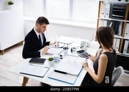 In der Nähe von zwei Geschäftsleute, die Berechnung des finanziellen Erklärung am Schreibtisch Stockfoto