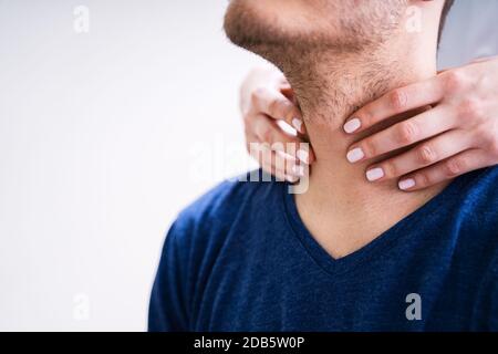 Nahaufnahme Der Hand Eines Arztes, Der Die Kehle Eines männlichen Patienten In Der Klinik Berührt Stockfoto