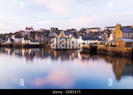 Morgenlicht im Hafenblick auf Stromness Hafen mit Weiß Häuser und Reflexionen im Wasser Stockfoto