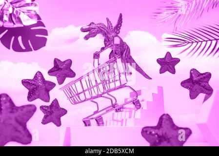 Ein goldener Dinosaurier auf Flügeln mit einem Trolley senkt die Treppe zum Einkaufen, um den Himmel, rote Sterne, Palmblätter, das Konzept eines großen Verkaufs, Black Friday. Stockfoto