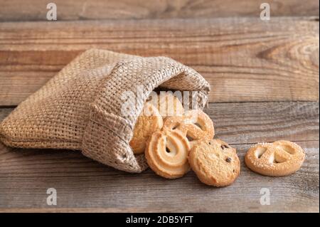 Butterkekse in Burlapentasche auf Holztisch Stockfoto
