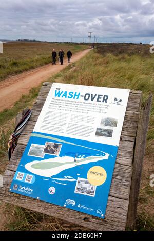 Ein Plakat über die Überwaschung und Überreste der Straße, die nach der Verflutung auf Yorkshires East Coast, Großbritannien, die durch einen Sturmflut im Jahr 2013 zerstört wurde, zeigen. Th Stockfoto