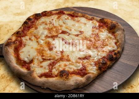 Pizza mit Tomatensouce und Mozzarella-Käse auf einem hölzernen Platine Stockfoto