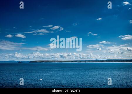 Ein kleines weißes Fischerboot auf St Ives Bay, Cornwall an einem blauen Sommertag. Stockfoto