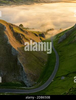 Kurvenreiche Straße Mit Golden Misty Light Im Peak District. Stockfoto