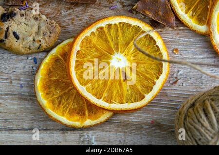 Getrocknete Orangen, Schokoladenscheiben, Schokoladenkekse und Zimt auf einem Holztisch. Stockfoto