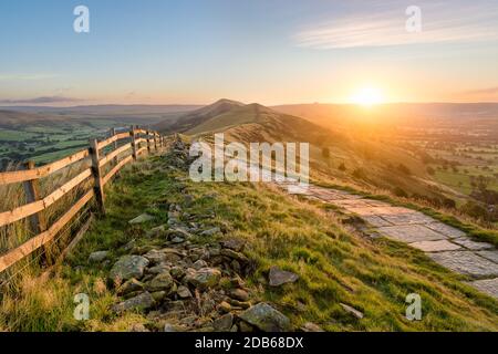 Steinfußweg und Holzzaun führen einen langen Great Ridge im English Peak District. Stockfoto